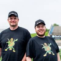 Dan Bohle and Andrew Johnson posing together in their matching 'corn' t-shirts and "The Corny Dudes" hats